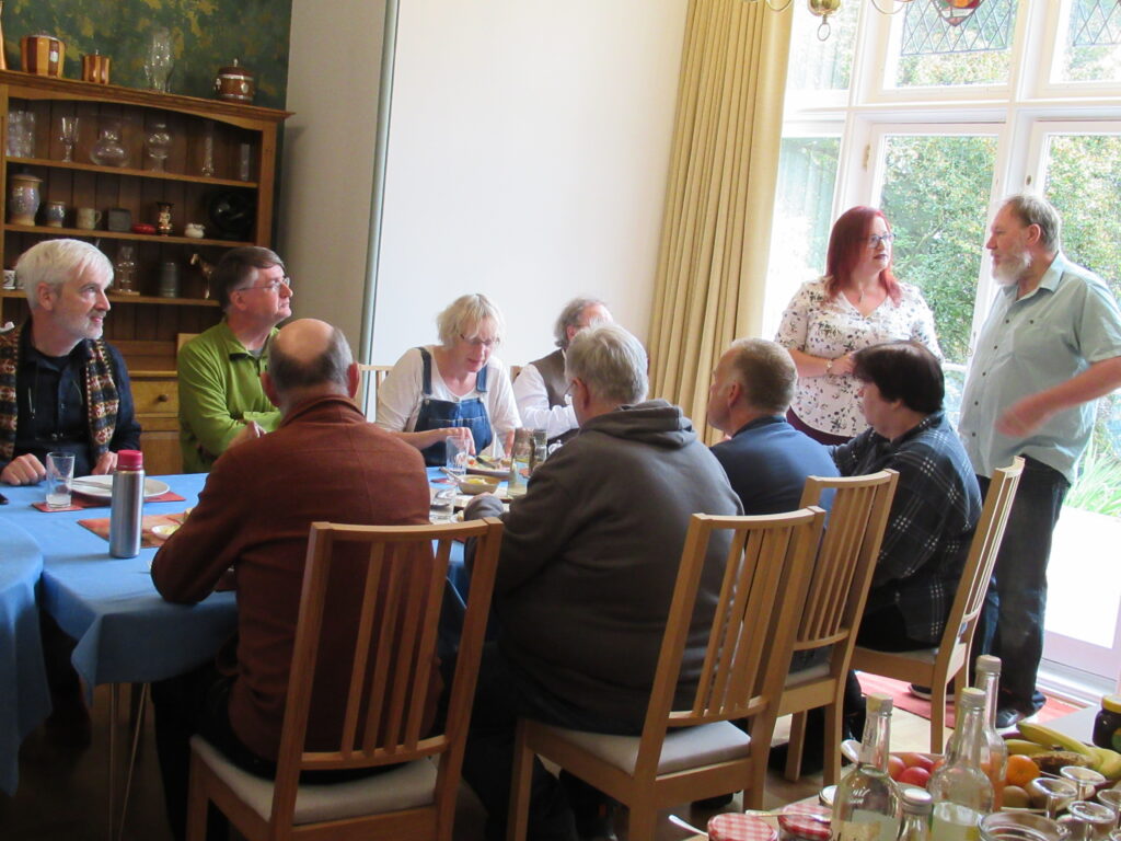 Guests around the table with two suspects in modern clothes